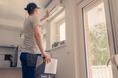 Repair Technician Inspecting a Window AC
